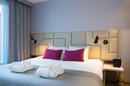 a bedroom with a large bed with towels on it at Mercure Krakow Stare Miasto in Kraków