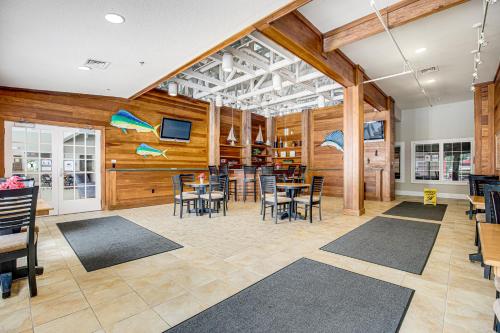 a dining room with tables and chairs and wooden walls at Bayside Bethany Lakes - S Mill #177 in Ocean View