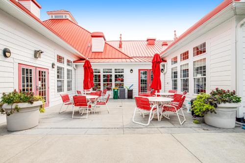 a patio with tables and chairs and red umbrellas at Bayside Bethany Lakes - S Mill #177 in Ocean View