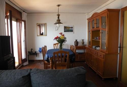 una sala de estar con una mesa con un jarrón de flores en Sea breeze, en Vilanova i la Geltrú