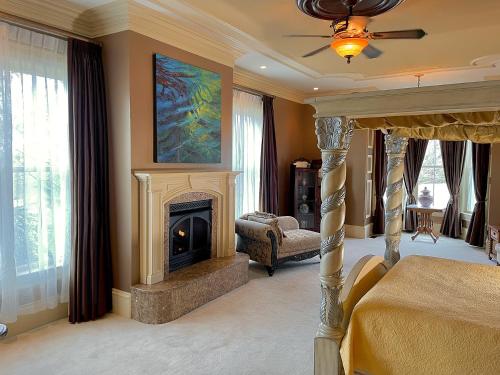 a bedroom with a fireplace and a bed and a painting at Wildflower Ranch Inn in Springfield