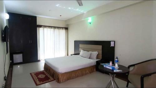 una camera d'albergo con letto, tavolo e comodino Sidx di Coastal Peace a Cox's Bazar