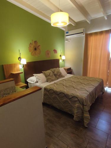 a bedroom with a bed and a green wall at Hostería Magnolia in Villa Gesell