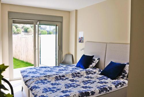 a bedroom with a bed with a blue comforter at Baviera Hills 1a in Málaga