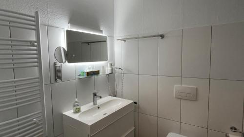Baño blanco con lavabo y espejo en Eifelerhof hotel Monschau en Monschau