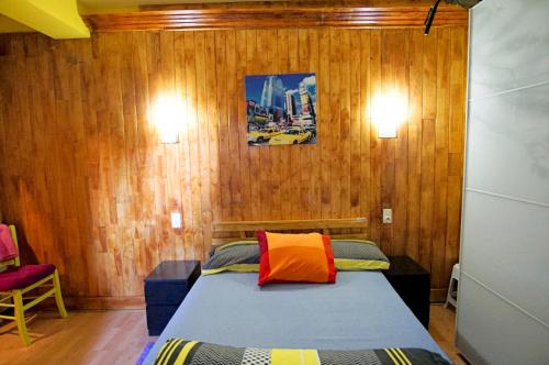 1 dormitorio con 1 cama con paredes de madera y 2 luces en Apto cerca de Puigcerda con chimenea, en Bourg-Madame