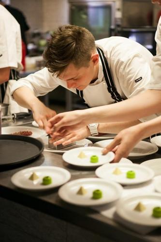a man in a kitchen preparing plates of food at Hotel Graffit in Świebodzin