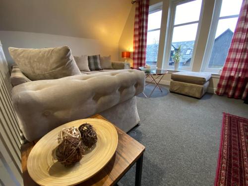 a living room with a couch and a table at Balmaha Lodges and Apartments in Balmaha