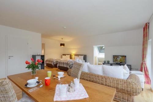 a living room with a couch and a bed at Harz-Urlaubs-Alm Hotel & Ferienhäuser in Clausthal-Zellerfeld