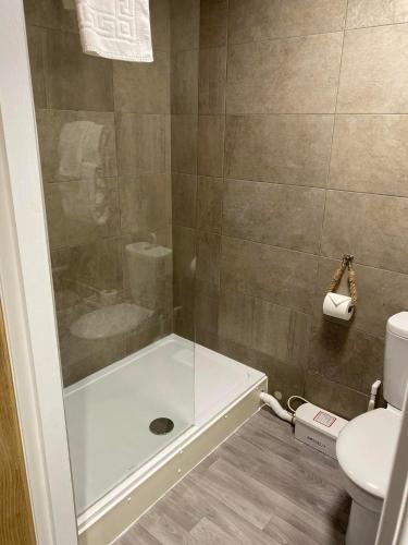 a bathroom with a shower with a tub and a toilet at Balmaha Lodges and Apartments in Balmaha