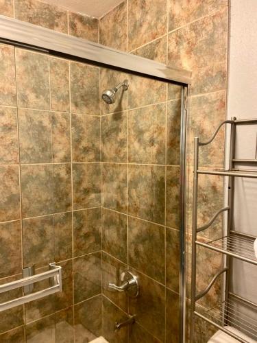 a shower with a glass door in a bathroom at Desert Getaway in Desert Hot Springs