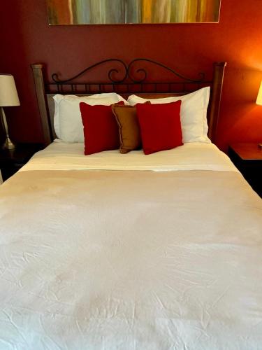 a large bed with red and white pillows on it at Desert Getaway in Desert Hot Springs
