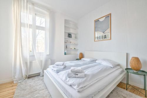 a white bedroom with a white bed and a window at Dom & House - Apartamenty Kamienica Sopocka 150 metrów od plaży in Sopot