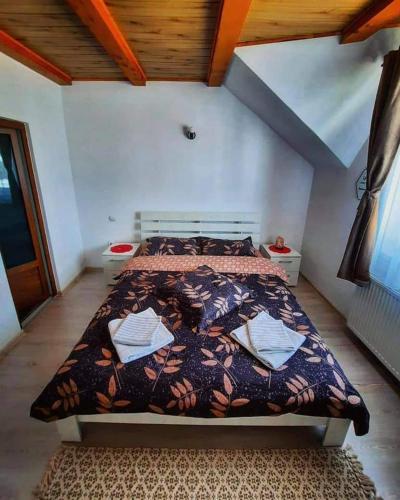 ein Schlafzimmer mit einem Bett mit einer Bettdecke darauf in der Unterkunft Casa Flavia in Poiana Mărului