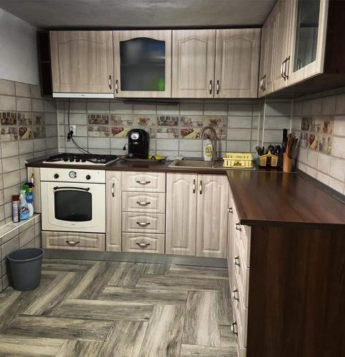 eine Küche mit weißen Geräten und Holzschränken in der Unterkunft Casa Flavia in Poiana Mărului