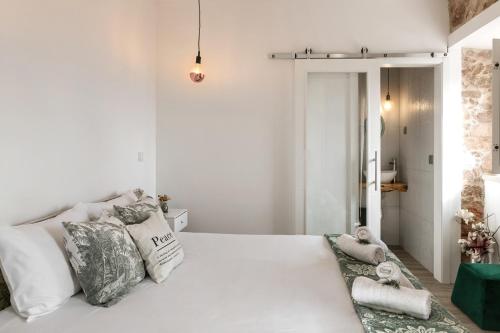 a white bedroom with a large white bed with pillows at Casa Trilhos da Serra in Alcobertas