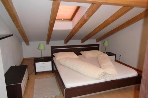 a bedroom with a bed with white sheets and two lamps at Neuprantl Apartments in Lana