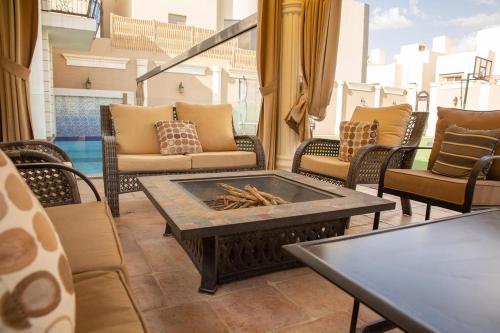 a patio with chairs and a table and a fire pit at Mostar Resort in Riyadh