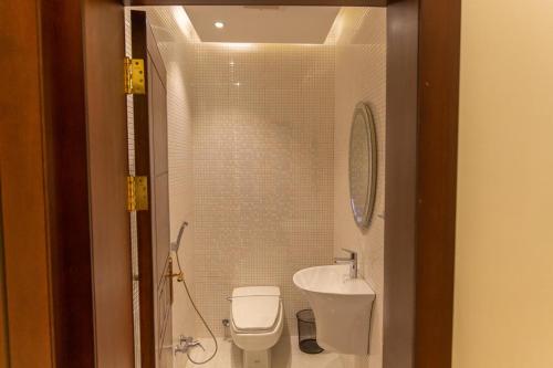 a small bathroom with a toilet and a sink at Mostar Resort in Riyadh