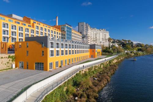 a row of yellow buildings next to a river at Pestana Douro Riverside - Preferred Hotels & Resorts, Lifestyle in Porto