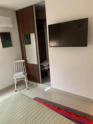 1 dormitorio con 1 cama, TV y silla en Depto Art Jujuy Capital en San Salvador de Jujuy