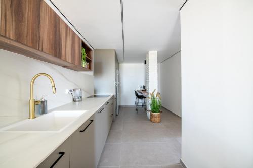 a kitchen with white counters and a sink and a table at דירת 3 חדרי שינה מרווחת עם נוף לים in Eilat
