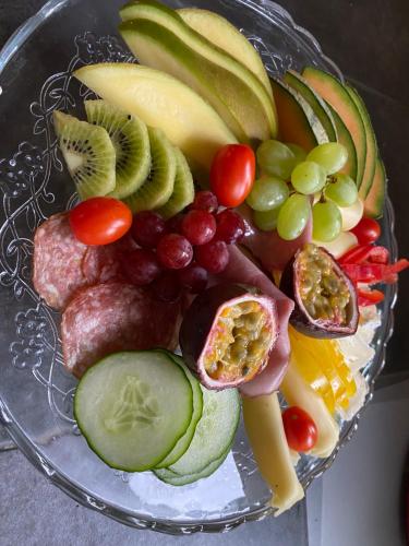 a plate of fruit and vegetables on a table at B&B Bland ormbunkar och rosor in Falkenberg