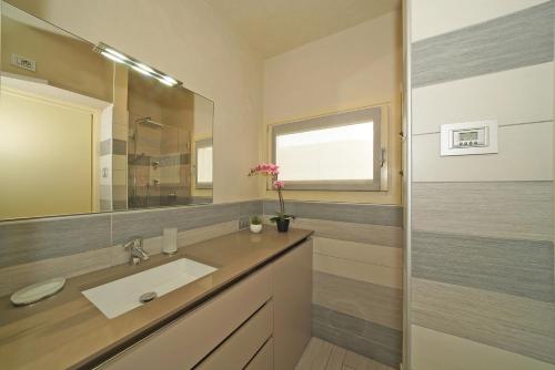 un baño con lavabo y espejo en Appartamento Elena, en Manerba del Garda