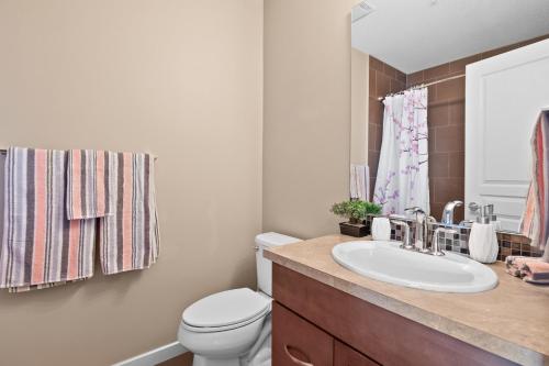 a bathroom with a white toilet and a sink at Stylish Downtown Condos by GLOBALSTAY in Calgary