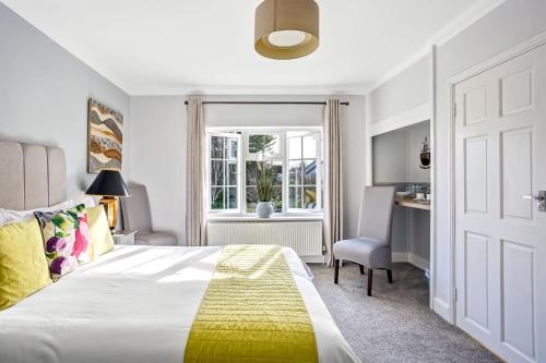a bedroom with a bed and a desk and a window at The Coast House B&B and Spa in Bognor Regis