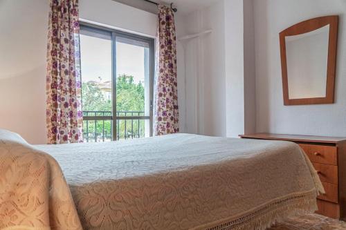 1 dormitorio con cama y ventana grande en Apartamento Señorio, en Rincón de la Victoria