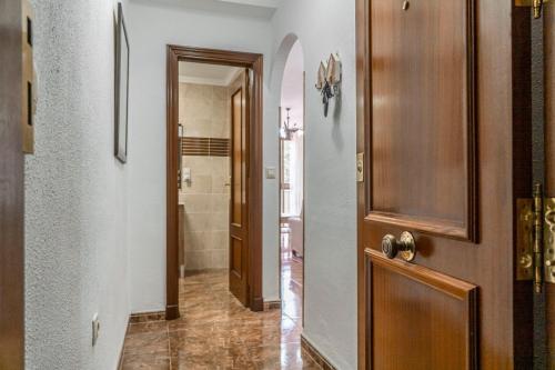 pasillo con puerta de madera y baño en Apartamento Señorio, en Rincón de la Victoria