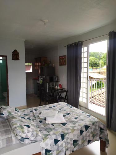 Schlafzimmer mit einem Bett und einer Glasschiebetür in der Unterkunft Kitnet em Alter do Chão in Alter do Chao