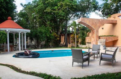 una piscina con sillas, un pérgola y una fuente en VILLA RODA Luxury & Art, en Cancún