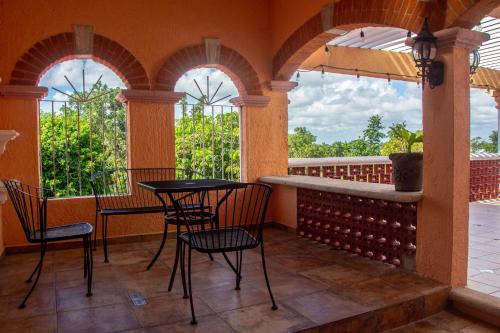 porche con mesa, sillas y ventanas en VILLA RODA Luxury & Art, en Cancún