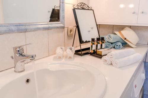 a bathroom counter with a sink and a mirror at Lighthouse apartment in Corfu Town
