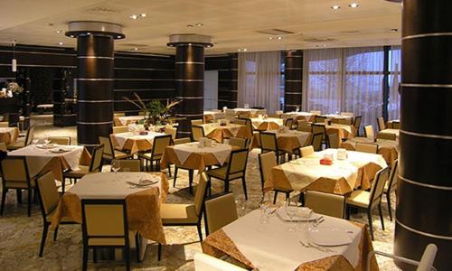 
a large dining room with tables and chairs at Dado Hotel International in Parma
