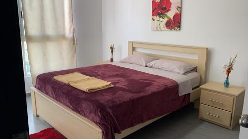 1 dormitorio con 1 cama grande con manta morada en KattySuit, en Salinas