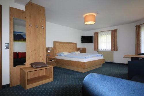 ein Hotelzimmer mit einem Bett und einem TV in der Unterkunft Landhaus Seehof in Füssen