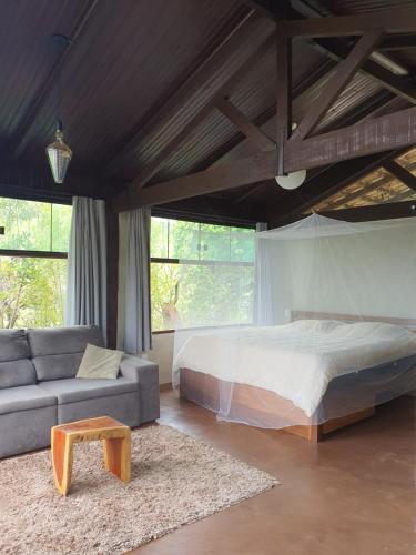 a bedroom with a bed and a couch and a table at Vila Paraíso in Alto Paraíso de Goiás