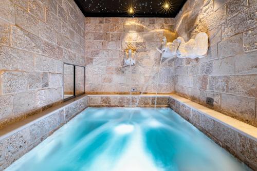 a hot tub in a room with a stone wall at Fountain - Suite Santeramo in Santeramo in Colle