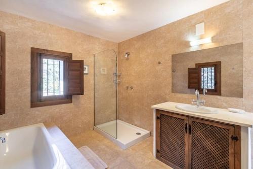 a bathroom with a tub and a sink and a shower at La Casa 1950 in Montefrío