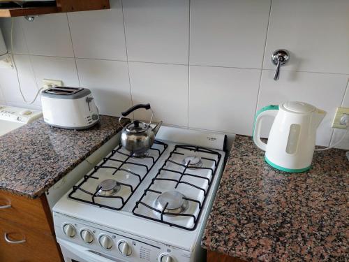 a kitchen stove with a tea pot on top of it at Dpto. luminoso, céntrico, nuevo: LA SERENA in Tandil