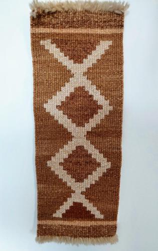 a brown and white rug with white stitching on it at Dpto. luminoso, céntrico, nuevo: LA SERENA in Tandil