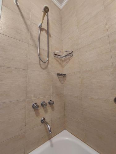 a bathroom with a shower with a tub and a sink at Dpto. luminoso, céntrico, nuevo: LA SERENA in Tandil
