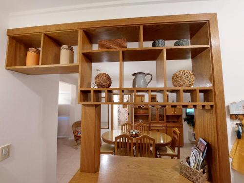 a kitchen and dining room with wooden shelves at Dpto. luminoso, céntrico, nuevo: LA SERENA in Tandil