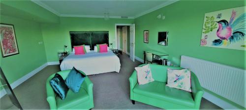 a green bedroom with a bed and two chairs at Patricks Boathouse in Swansea
