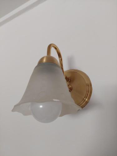 a brass light with a white shade on a ceiling at Dpto. luminoso, céntrico, nuevo: LA SERENA in Tandil
