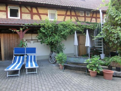 two blue chairs and umbrellas in front of a house at Zehnthof in Geldersheim