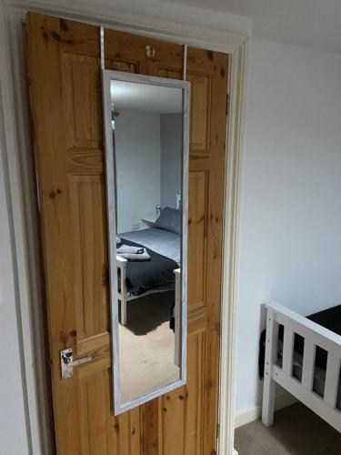 a door with a mirror in a room with a bed at Cosy 3-bedroom house, stones throw to beach in Weymouth